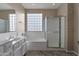 Bright bathroom featuring double sinks, a bathtub, a glass block window, and a separate shower at 18611 E Raven Dr, Queen Creek, AZ 85142