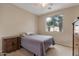 Bedroom with neutral decor and a view of palm trees outside the window, creating a relaxing atmosphere at 18611 E Raven Dr, Queen Creek, AZ 85142