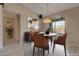 Cozy dining room featuring stylish chairs, modern chandelier, and sliding door access to patio at 18611 E Raven Dr, Queen Creek, AZ 85142