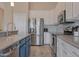 Well-lit kitchen featuring stainless steel appliances, granite counters and blue and white cabinetry at 18611 E Raven Dr, Queen Creek, AZ 85142