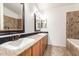 Bathroom featuring dual sinks, vanity, mirror, and tiled tub surround at 1920 E Belmont Dr, Tempe, AZ 85284