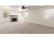 Spacious living room featuring a brick fireplace, neutral carpet, ceiling fan and ample natural light at 1920 E Belmont Dr, Tempe, AZ 85284