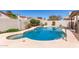 Private pool with a baja shelf, stainless steel handles, and cool decking surrounded by block fence and landscaping at 1920 E Belmont Dr, Tempe, AZ 85284