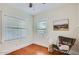 Cozy bedroom with hardwood floors, two bright windows, and a comfortable chair at 2034 N Dayton St, Phoenix, AZ 85006