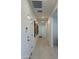 Long hallway with light tile floors, white doors, recessed lighting, and artwork on the wall at 20610 W Vermont Ave, Buckeye, AZ 85396