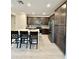 Modern kitchen featuring an island with bar stool seating, stainless steel appliances, and gray backsplash at 20610 W Vermont Ave, Buckeye, AZ 85396