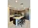 Modern kitchen featuring an island with bar stool seating, stainless steel appliances, and gray backsplash at 20610 W Vermont Ave, Buckeye, AZ 85396