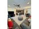 Spacious living room with a fan, gray sofa, adjacent to modern kitchen with an island and a dining area at 20610 W Vermont Ave, Buckeye, AZ 85396