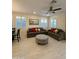 Open living room with two sofas, decorative pillows, and a round upholstered ottoman on light tile floor at 20610 W Vermont Ave, Buckeye, AZ 85396