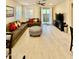 Bright living room features a plush sectional sofa, designer ottoman, and sliding glass doors leading to outdoor space at 20610 W Vermont Ave, Buckeye, AZ 85396