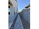 Narrow side yard with a stone walkway and a block wall, connecting the front and back of the property at 20610 W Vermont Ave, Buckeye, AZ 85396