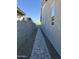 Side yard featuring a stone walkway, landscaping rocks, and a block wall, offering privacy at 20610 W Vermont Ave, Buckeye, AZ 85396