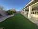 A spacious backyard featuring lush artificial turf, a stone landscape border and covered patio, perfect for relaxation at 20822 N 42Nd. Ave, Glendale, AZ 85308