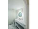 Modern powder room with marble floors, floating vanity, and circular lighted mirror at 20822 N 42Nd. Ave, Glendale, AZ 85308