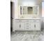 A double vanity featuring modern sinks, bright vanity lighting and white cabinetry with bronze handles at 20822 N 42Nd. Ave, Glendale, AZ 85308
