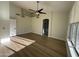 Bright bedroom featuring wood floors, neutral walls, a ceiling fan, and access to a bathroom and hallway at 20822 N 42Nd. Ave, Glendale, AZ 85308
