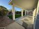 Covered patio with stained concrete and a low-maintenance landscape with stone and artificial turf at 20822 N 42Nd. Ave, Glendale, AZ 85308