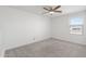 Carpeted bedroom with ceiling fan and window offering natural light at 21572 W Sonora St, Buckeye, AZ 85326