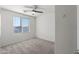 Well-lit bedroom featuring carpeted floors, a ceiling fan, and a large window at 21572 W Sonora St, Buckeye, AZ 85326