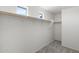 An empty walk-in closet featuring custom shelves, a hanging rod, and natural light from a window at 21572 W Sonora St, Buckeye, AZ 85326