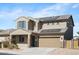 Two-story home showcasing a tile roof, two-car garage, solar panels, and low-maintenance desert landscaping at 21572 W Sonora St, Buckeye, AZ 85326