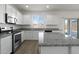 Bright kitchen features white cabinets, granite countertops, stainless steel appliances, and wood-look flooring at 21572 W Sonora St, Buckeye, AZ 85326