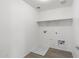 Functional laundry room with overhead shelving and hookups at 21572 W Sonora St, Buckeye, AZ 85326