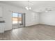Open living room features wood-look flooring, abundant natural light from sliding glass door and windows at 21572 W Sonora St, Buckeye, AZ 85326