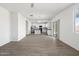 Expansive living area with wood-look flooring, ceiling fan, adjacent kitchen and sliding door to patio at 21572 W Sonora St, Buckeye, AZ 85326