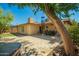 Private backyard featuring a stone patio, artificial lawn, dining table, and mature trees for shade at 2246 E Glenrosa Ave, Phoenix, AZ 85016