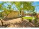 The backyard features an artificial lawn, mature trees, and a cozy seating area at 2246 E Glenrosa Ave, Phoenix, AZ 85016