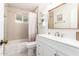 Bright bathroom featuring a shower-tub combo, white vanity, decorative mirror and tiled walls at 2246 E Glenrosa Ave, Phoenix, AZ 85016