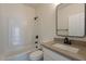 Cozy bathroom featuring a shower-tub combo and a stylish framed mirror at 2311 N Loma Vis, Mesa, AZ 85213