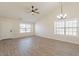 Open-concept living space features wood-look floors, vaulted ceiling, and bright windows at 2311 N Loma Vis, Mesa, AZ 85213
