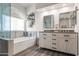 Bright bathroom with a dual sink vanity, tub, and wood-look flooring at 2537 E Vista Bonita Dr, Phoenix, AZ 85024