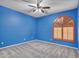 Bright blue bedroom featuring a ceiling fan and window with shutters at 25453 N 68Th Ln, Peoria, AZ 85383