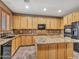 Well-lit kitchen with granite counters, wood cabinetry, and a functional center island at 25453 N 68Th Ln, Peoria, AZ 85383