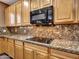 This kitchen has wood cabinets, granite counters, and modern appliances at 25453 N 68Th Ln, Peoria, AZ 85383