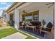 Covered back patio with modern furniture, ceiling fan, and views of a manicured backyard at 25800 N 140Th Ln, Surprise, AZ 85387