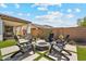 A backyard seating area with artificial turf, desert plants, a fire pit, and comfortable seating at 25800 N 140Th Ln, Surprise, AZ 85387