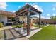 Beautiful backyard featuring a covered patio with dining, artificial turf, and desert landscaping at 25800 N 140Th Ln, Surprise, AZ 85387