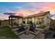 Beautiful backyard featuring desert landscaping, a pergola, sitting area, and a covered patio for outdoor entertaining at 25800 N 140Th Ln, Surprise, AZ 85387