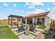 Landscaped backyard with artificial turf, concrete pavers, desert plants, and covered patio seating area at 25800 N 140Th Ln, Surprise, AZ 85387