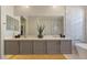 Bathroom boasts dual sinks, floating gray cabinets, and a modern shower with hexagonal tile at 25800 N 140Th Ln, Surprise, AZ 85387