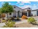 Charming single-story home featuring a tile roof, arched entryway, desert landscaping, and a two car garage at 25800 N 140Th Ln, Surprise, AZ 85387