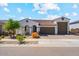 Charming single-story home featuring a tile roof, arched entryway, desert landscaping, and a two car garage at 25800 N 140Th Ln, Surprise, AZ 85387