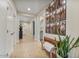 Bright hallway featuring tile floors, white doors, and a wooden bench with a plant, illuminated by recessed lighting at 25800 N 140Th Ln, Surprise, AZ 85387