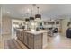 Open-concept kitchen with a large island connecting to the living and dining areas at 25800 N 140Th Ln, Surprise, AZ 85387