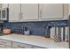 Close up of kitchen counter featuring dark subway tile backsplash and decorative items at 25800 N 140Th Ln, Surprise, AZ 85387
