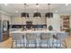Bright, open kitchen featuring an island with seating and modern pendant lighting at 25800 N 140Th Ln, Surprise, AZ 85387